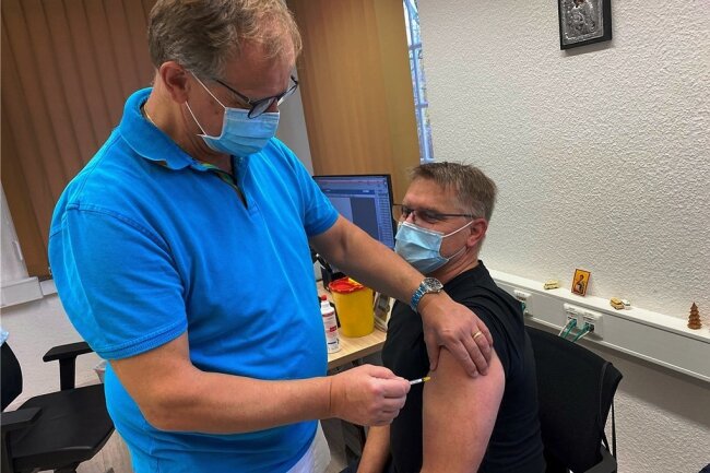 Hausarzt Dr. Jan Anastassis Skuras impft in seiner Praxis in Lichtenwalde den 48-jährigen Jens Gräbner. Der Chemnitz erhält seine Booster-Impfung. 
