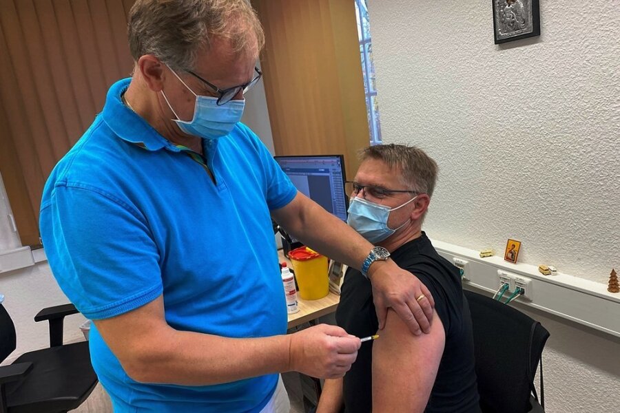 Hausarzt Dr. Jan Anastassis Skuras impft in seiner Praxis in Lichtenwalde den 48-jährigen Jens Gräbner. Der Chemnitz erhält seine Booster-Impfung. 