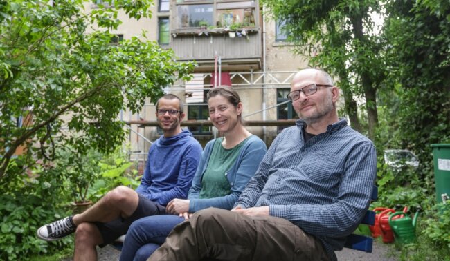 René Härtel (von links), Jana Pöttrich und Jörg Lenk sitzen im Garten der "Alten Cäcilie". Gemeinsam mit den anderen Bewohnerinnen und Bewohnern des Hauses haben sie eine Genossenschaft gegründet und das Gebäude übernommen. Bald stehen Renovierungsarbeiten an. 