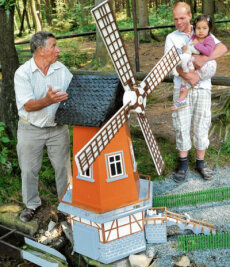 Heimateck "Rentnersruh" lockt mit Sommerfest nach Thalheim - Diese Windmühle ist eines der größten Modelle in der "Rentnersruh". Gebaut wurde sie 1968 von Herbert Preiß. Heinz Hahn (links) stellt sie dem ehemaligen Meinersdorfer Heiko Scholz mit Tochter Vanessa vor.