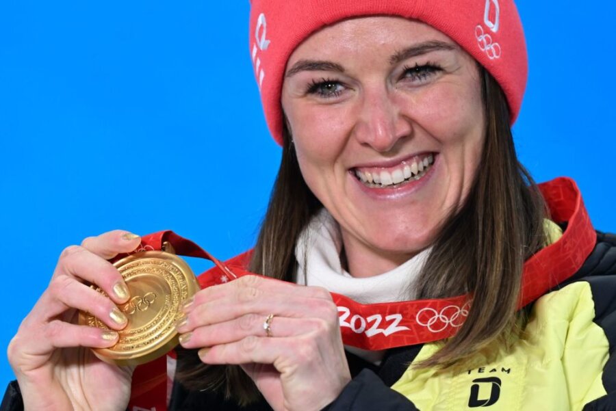 Die Biathletin Denise Herrmann aus Deutschland jubelt mit ihrer Goldmedaille.