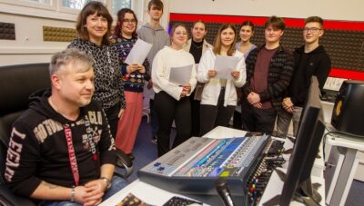 Heiße Phase für neue Stadt-Hymne - Produzent Christian Winter (links), Musiklehrerin Kathrin Büchold und ein Teil des Lessing-Chores probte jüngst erstmals im Studio. 
