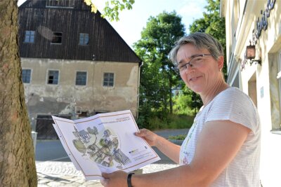 Helbigsdorf: So soll das neue Ortszentrum aussehen - Am Gasthof in Helbigsdorf zeigt Katrin Weigold vom Ortsverein „Drei weiße Birken“ die Pläne für das Ortszentrum.