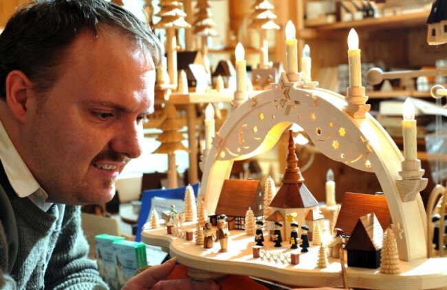 Heller Schein aus winzigen Fenstern - 
              <p class="artikelinhalt">Häuselmacher Roman Naumann mit seinem werkstattübergreifenden Schwibbogen. </p>
            