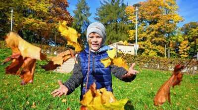 Herbstsonne macht den Park zum Erlebnis - Im Stadtpark in Hainichen ließ am Montag der fünfjährige Jannes Karl die Blätter tanzen.