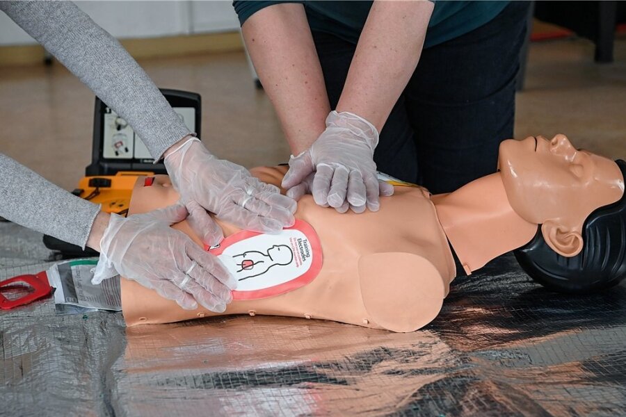 "Herzsicher" in Aue-Bad Schlema: Stadt will Defibrillatoren an öffentlichen Plätzen aufstellen - Ausbilderinnen demonstrieren an einer Reanimationspuppe die Wiederbelebung mit Einsatz eines Defibrillators.
