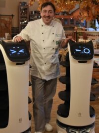 Hier servieren jetzt Roboter - Silvio Kuhnert mit seinen neuen Helfern: Zwei Roboter werden künftig die Gäste in seinem Restaurant bedienen. Die Geräte mit Katzengesicht wurden auf die Namen Bella und Robby getauft. 