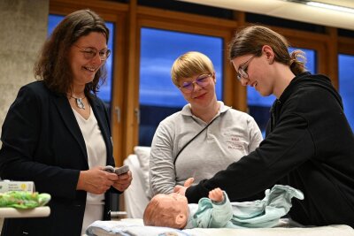 Hilfe auf dem Weg zum Beruf in Rochlitz - Besucher wie Lena erlebten wie ein Baby gewickelt wird. Lehrerin Anja Kunze (li.) und Auszubildende Susan Rößger (Mitte) gaben Ratschläge.