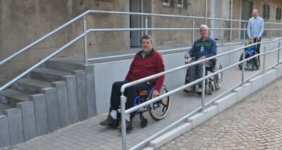 Hilfe für Modellbahner im Rollstuhl - Die Brüder Frank und Gunter Liebers sowie Eisenbahner Robin Helmert mit Jona Sieber (v. l.) testen die neue Auffahrt zum Vereinshaus.
