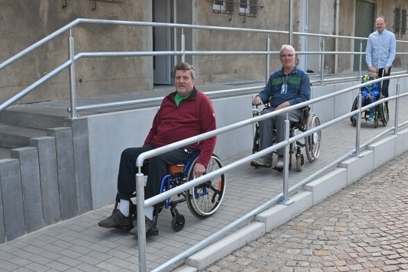 Hilfe für Modellbahner im Rollstuhl - Die Brüder Frank und Gunter Liebers sowie Eisenbahner Robin Helmert mit Jona Sieber (von links) testen die neue Auffahrt zum Vereinshaus.