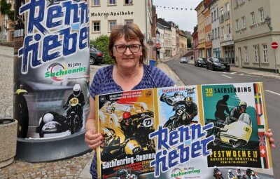Historische Plakate werben für 95 Jahre Sachsenring - Ute Weißbach, Geschäftsführerin des Fremdenverkehrsvereins, mit dem neu gestalteten Plakat. Das Sammlerstück wurde in einer Auflage von 250 Stück geordert und ist für 2,50 Euro erhältlich.