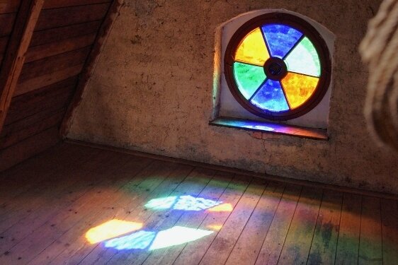 Farbenspiel durch ein Fenster auf dem Dachboden.