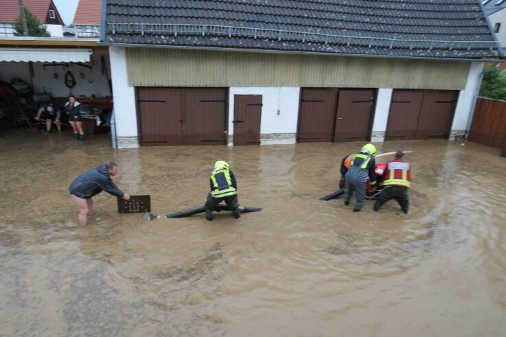 Hochwasser in Glauchau: "Das war schlimmer als 2013" - Helfer und Feuerwehrleute standen auf dem Hof an der Bachstraße am Samstag teilweise kniehoch in der braunen Brühe. 