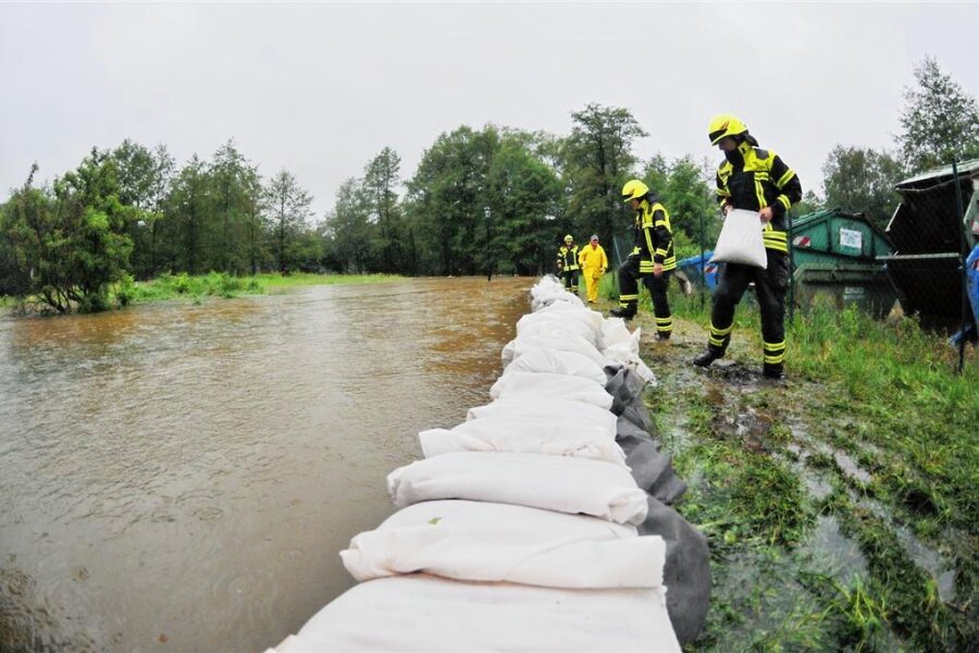 Hochwasserschutz im Vogtland: Neue Gefahrenkarten könnten Hausbesitzer kalt erwischen - Hochwasser in Oelsnitz: Feuerwehrleute sicherten ein Firmengelände in der Elsteraue gegen die Flut. Das Bild entstand 2013.