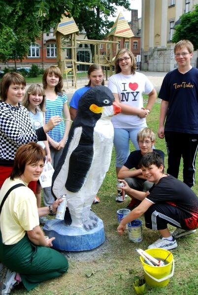 Holzfiguren und Spielanlageverschönern den Schulhof - Schüler der Mittelschule Falkenstein haben eine Pinguin-Skulptur aus Holz als Blickfang für den neuen Schulhof geschaffen. 
