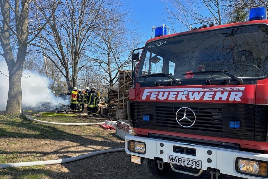 Holzstapel brennt in Lauterbach: Feuerwehren verhindern größeren Brand - Mit Atemschutztechnik rückten die Kameraden dem Brand zu Leibe. Foto: Thomas Wittig