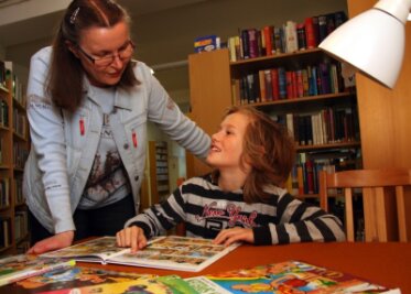 "Ich will Papierseiten umblättern" - 
              <p class="artikelinhalt">Michaela Löschner, Mitarbeiterin der Bibliothek Lengefeld, erleichtert Elisabeth Teuchert die Auswahl ihrer Lektüre. Die Achtjährige ist ein großer Fan der Comicreihe "Asterix". </p>
            
