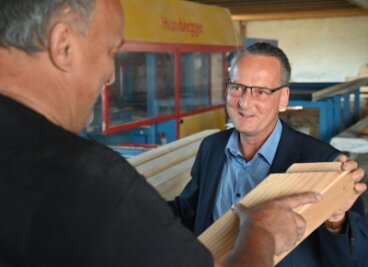 "Ich würde in eine kommunale Fotovoltaikanlage investieren" - Dirk Richter (rechts) auf Wahlkampftour in Taura im Gespräch über Handwerksarbeit mit dem Zimmerer Uwe Graichen. 