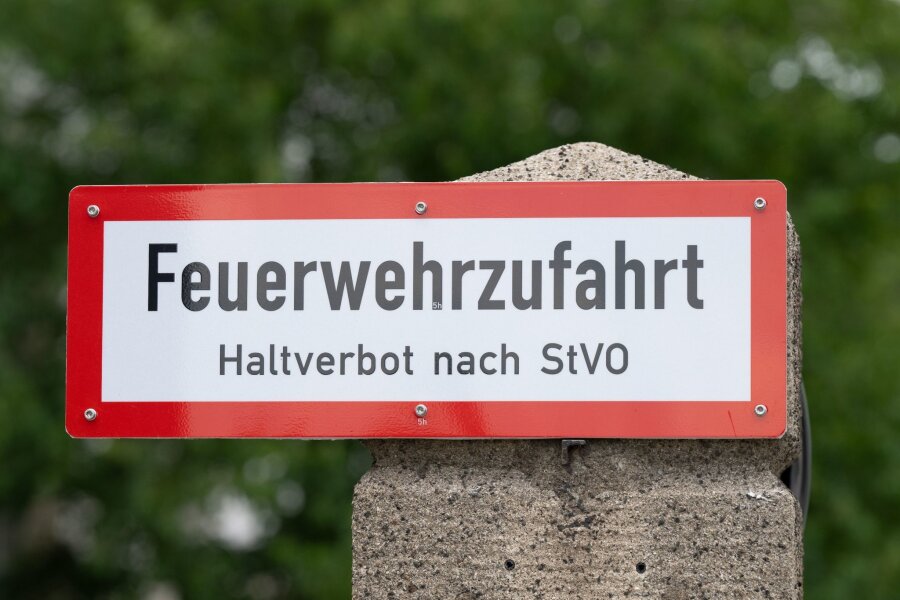 Immer öfter versperren Falschparker Rettungswege in Sachsen - Ein Schild mit der Aufschrift "Feuerwehrzufahrt" steht an einer Einfahrt.