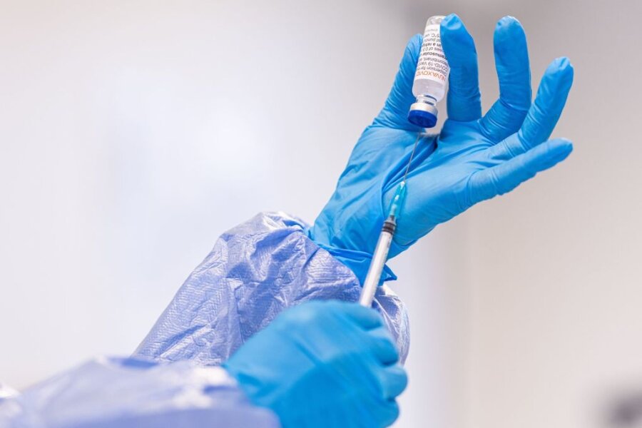 Eine Mitarbeiterin eines Impfzentrums hält eine Spritze in den Händen.