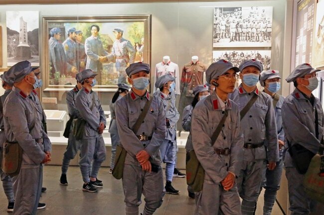 Eine Besuchergruppe im Revolutionsmuseum von Jinggangshan in China. Wohin sich einst Mao Tse-tung mit seinen roten Truppen zurückgezogen hatte, um den kommunistischen Volksaufstand zu planen, werden nun, mehr als 70 Jahre später, in einer Akademie Parteikader ideologisch auf Spur gebracht.
