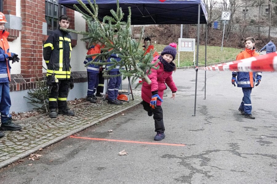In Mülsen fliegen die Tannenbäume: Zur Freude von etwa 350 Gästen - Vivien Exner (9) beim Weihnachtsbaumwerfen.