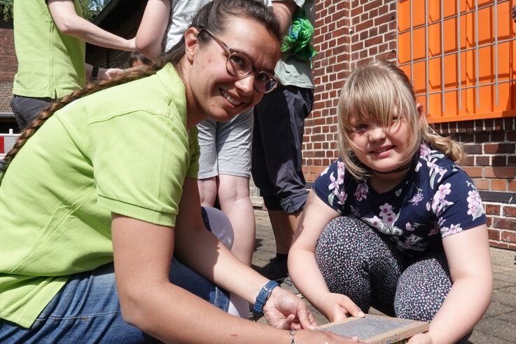 Tamar Klötzer (l.) vom ortsansässigen Kita-Verein erklärt der achtjährigen Luna das Papierschöpfen 