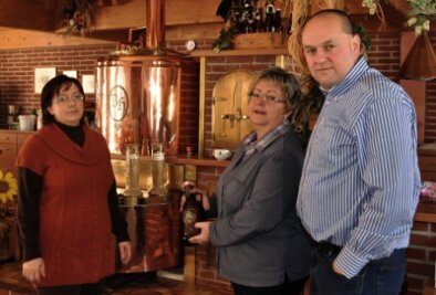 Inhaber vom Bayerischen Hof in Grünbach investieren kräftig - Stephanie Eger (links) und Michael Eger erhalten von ihrer Mutter Ines Apfelstädt den Staffelstab in Form einer Bierflasche.