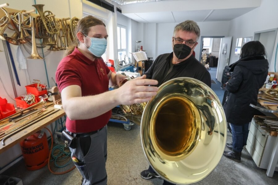 Bernhard Kroning (links) zeigt einem Besucher der Kunsthandwerkstage in seiner Werkstatt eine Tuba. Er selbst spielt dieses Instrument. 