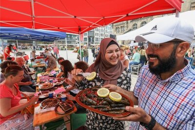 Internationale Küche auf dem Chemnitzer Neumarkt: Kultur geht durch den Magen - Amira und Kenan Allejji aus Syrien haben unter anderem mit Reis gefüllte Weinblätter gekocht.