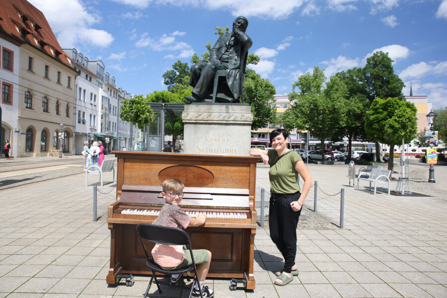 Am Samstag wird hier Robert Schumanns 214. Geburtstag gefeiert: Katrin Voigt mit Sohn Friedrich (10) aus Zwickau probieren das öffentliche Klavier aus. Auf der Hauptbühne vor dem Zwickauer Rathaus steht ein weiteres Instrument. 