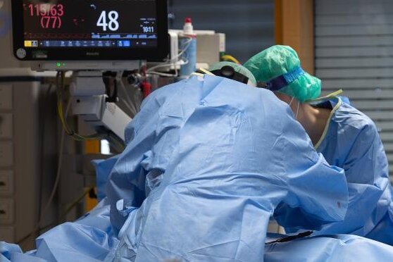Medizinisches Personal legt auf einer Intensivstation einem Covid-19-Patienten einen Zugang für die künstliche Beatmung.
