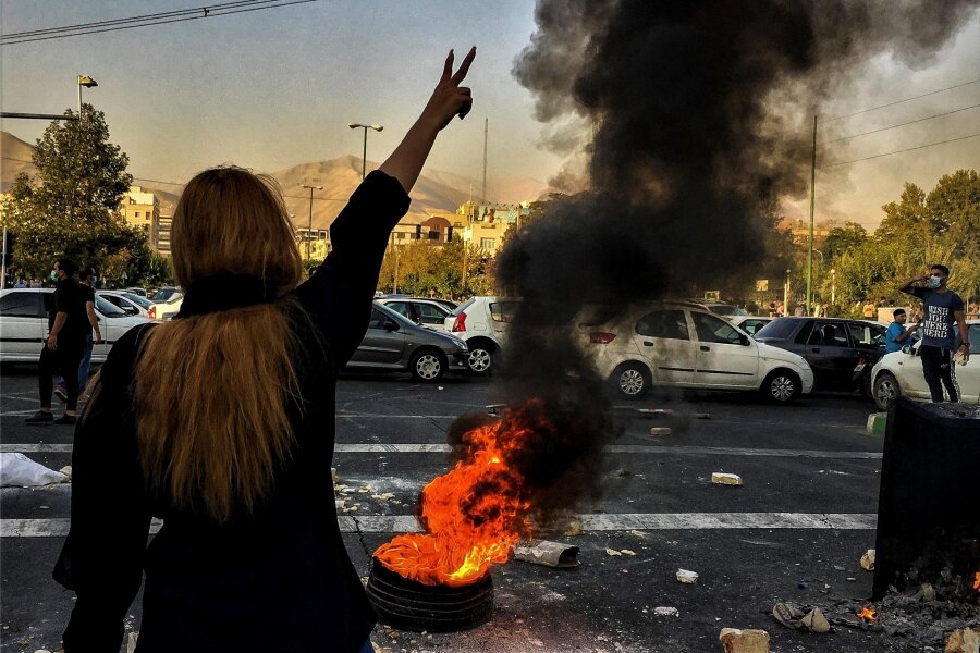 Iran steht vor neuer Machtprobe - Ohne Kopftuch: Eine Frau steht Ende September 2022 während einer Demonstration in Teheran auf der Straße. 