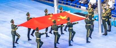 Ist China eigentlich noch kommunistisch? - Auch die Ausrichtung der Olympischen Winterspiele nutzt China, um sich als offen autoritärer Staat im Konzert der Weltmächte zu präsentieren: Chinesische Soldaten bringen die Flagge der Volksrepublik ins Olympiastadion in Peking. 