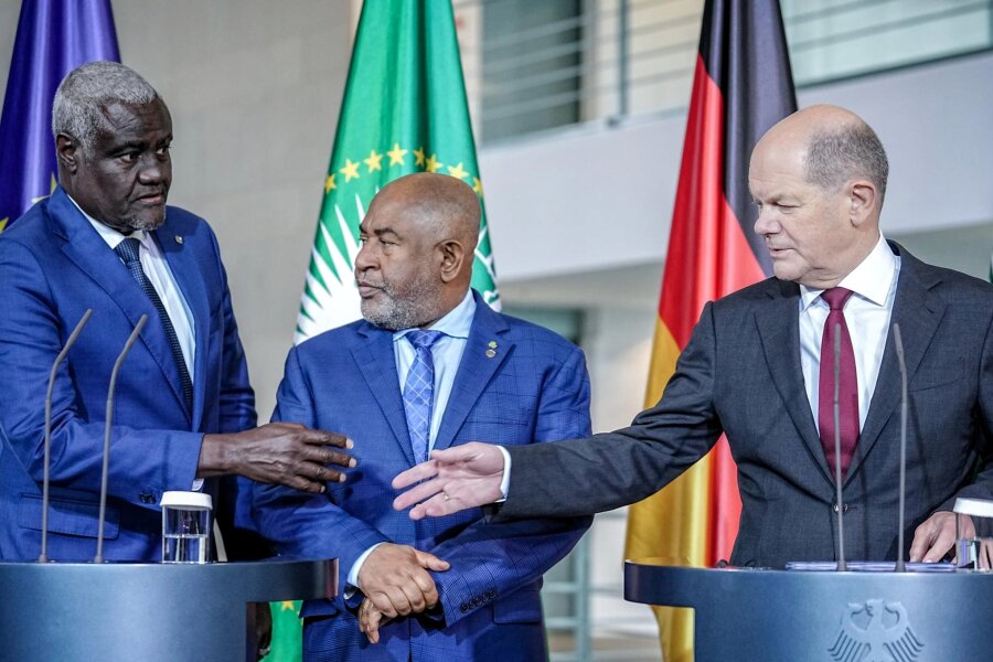 Ist Deutschland ein verlässlicher Partner für Afrika? - Bundeskanzler Olaf Scholz mit Azali Assoumani (M.), Präsident der Komoren und Vorsitzender der Afrikanischen Union, und Moussa Faki Mahamat, Generalsekretär der Afrikanischen Union, vor den Mikrofonen.