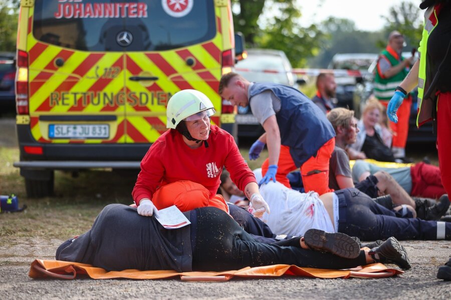 Johanniter bauen Katastrophenschutz in Sachsen aus - Notfallsanitäter in Ausbildung versorgen während einer Übung Menschen.