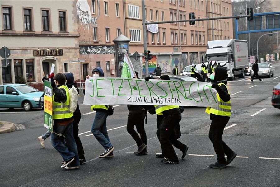 Jugendliche demonstrieren in Chemnitz für Verkehrswende - und werden mehrmals fast überfahren - Die Jugendlichen haben bei grüner Fußgängerampel Plakate über die Straße getragen. 