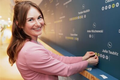 Julia Taubitz darf im Oberwiesenthaler Museum fünf Punkte kleben - Viel zu kleben: Insgesamt fünf WM-Medaillen hat Julia Taubitz an der riesigen Wand im "Wiesenthaler K3" nachgetragen. 