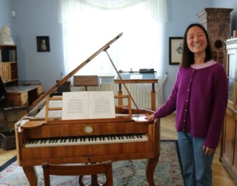 Junge Chinesin glücklich an Clara Schuhmanns Flügel - Pianistin Xinhui Wang vor Clara Schumanns Flügel. 