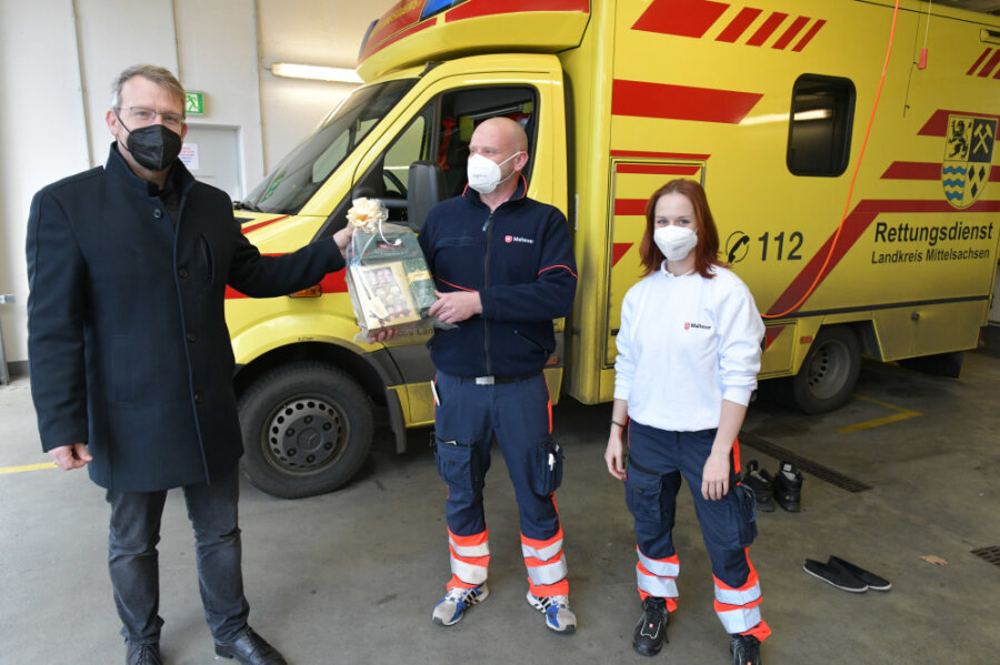 Kaffee für die Feuerwehr: Freibergs OB verteilt an Heilig Abend Geschenke - Oberbürgermeister Sven Krüger überreicht ein Geschenk an Rene Freudrich und Celeste Rochlitzer vom Malteser Hilfsdienst. 