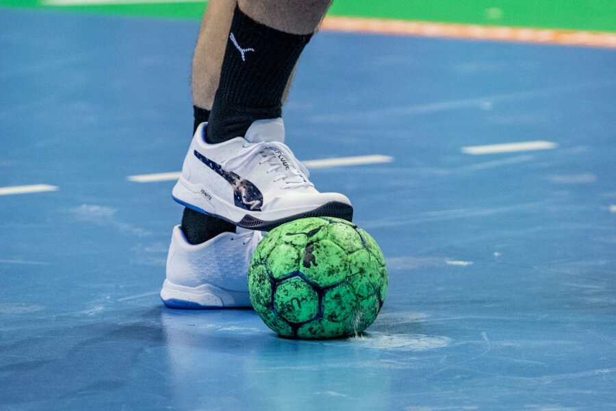 Kampf gegen Abstieg: Zwickau feiert gegen Halle 26:19-Erfolg - Ein Spieler hält einen Handball mit dem Fuß fest.