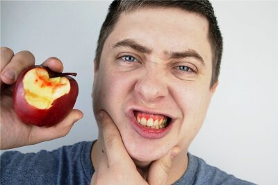 Kasse bezahlt nun Parodontitis-Nachsorge - Alarmzeichen rot: Das Zahnfleisch blutet beim Biss in den Apfel. 