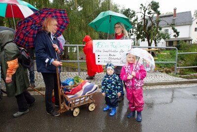 Kauschwitzer protestieren gegen Verzögerung des Fußwegbaus - Junge Eltern mit Kleinkindern, aber auch ältere Bürger haben sich mit Fahrrädern, Handwagen und Schubkarren an dem Protestmarsch auf der stark befahrenen Zwoschwitzer Straße beteiligt.