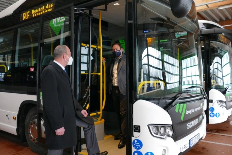 RVE-Geschäftsführer Roland Richter (vorn) und Scania-Verkaufsdirektor Luc Moulin schauen sich einen der neuen Hybridbusse an. 