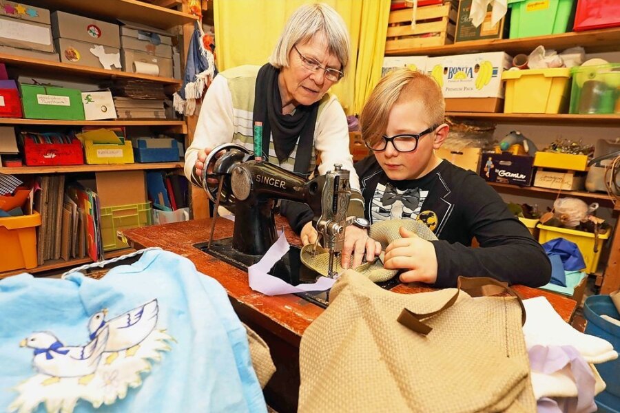 Kinder sitzen an der Nähmaschine - Horterzieherin Elisabeth Zimmer hilft dem zehnjährigen Lino Haegler an einer alten Singer-Nähmaschine.