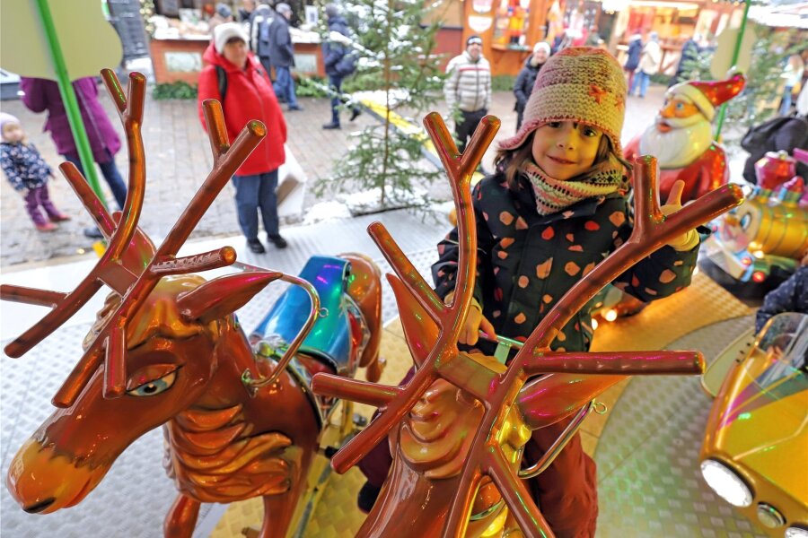 Kino, Basteln, Naschereien: Vier Tipps was Kinder auf dem Christmarkt in Freiberg erleben können - Die kleine Carmen auf dem großen Kinderkarussell: Jede Menge Spaß auf Elchen.