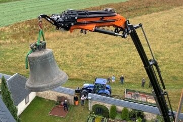 Die große Glocke wird per Kran auf einen Anhänger außerhalb des Friedhofs gesetzt.