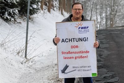 Klaus Kampf und sein langer Kampf: Bauversprechen für marode Staatsstraße - Klaus Kampf aus Neudorf bleibt skeptisch, was die Ankündigung zum Straßenbau betrifft. Er hebt seine Protestplakate daher auf. 