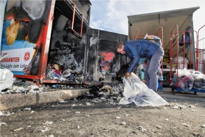 Kleidercontainer in Brand gesteckt: Inhalt geht komplett in Flammen auf - Die verkohlten Reste musste jetzt Michael Ritter in Mülltüten packen.