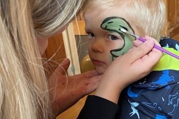 Kleiner Verein krempelt fürs Dorf die Ärmel hoch - Der zweijährige Wim lässt sich von Franziska Müller einen Saurier ins Gesicht schminken. 